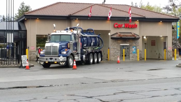 Vacuum truck cleaning a car wash catch basin