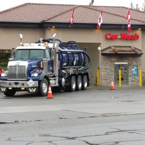 Vacuum truck cleaning a car wash catch basin