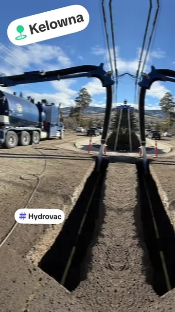 Two D&L hydrovac trucks digging trenches beside utility lines in Kelowna