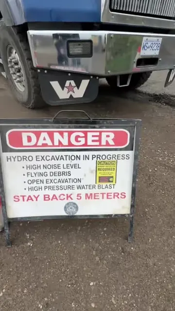 Hydro excavation warning sign in front of a D&L Western Star hydrovac truck